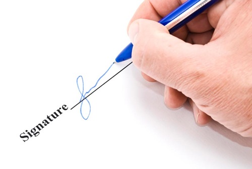 Hand with pen makes signature