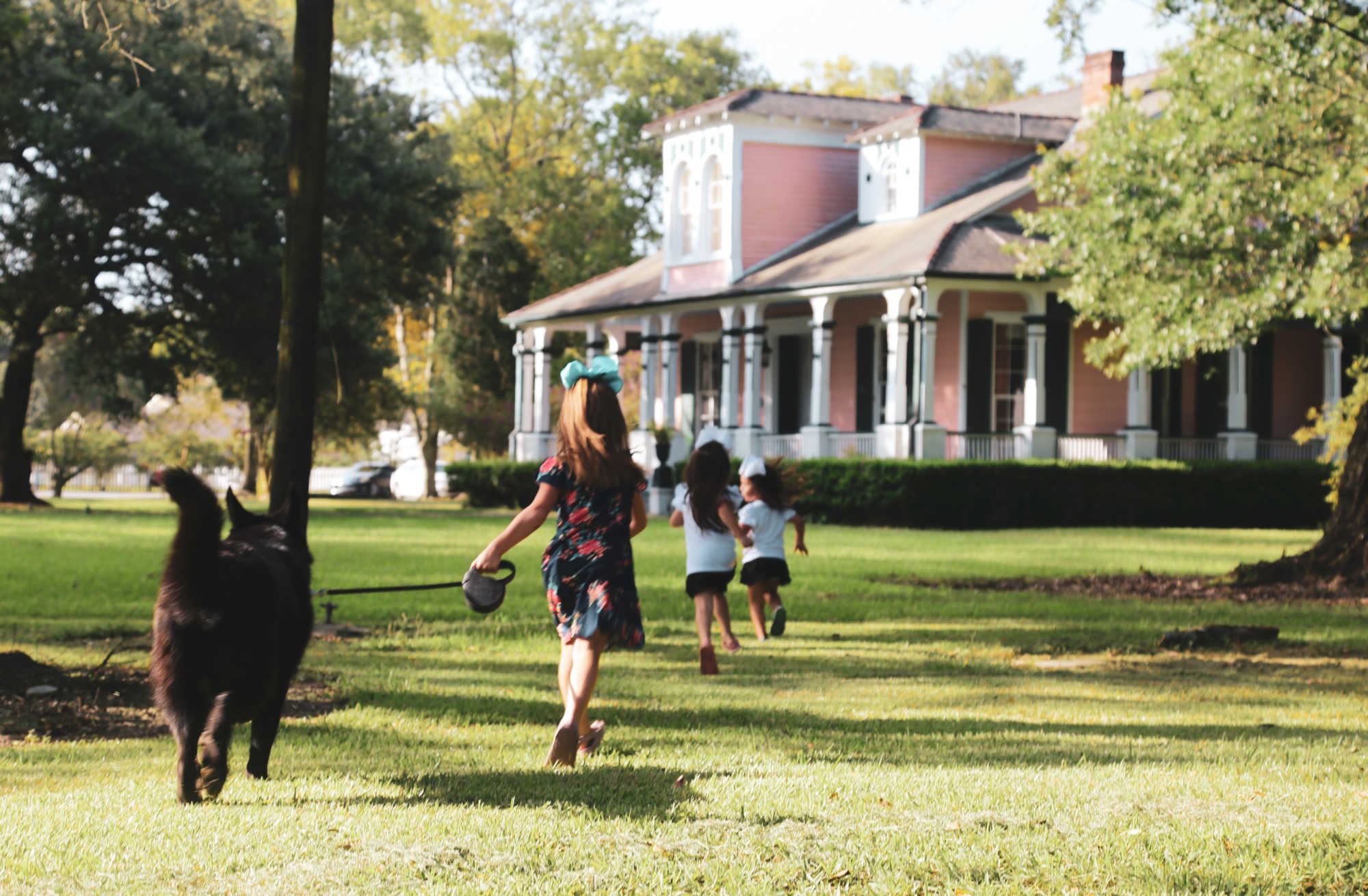 Children run and frolic on the lawn at Poche Plantation